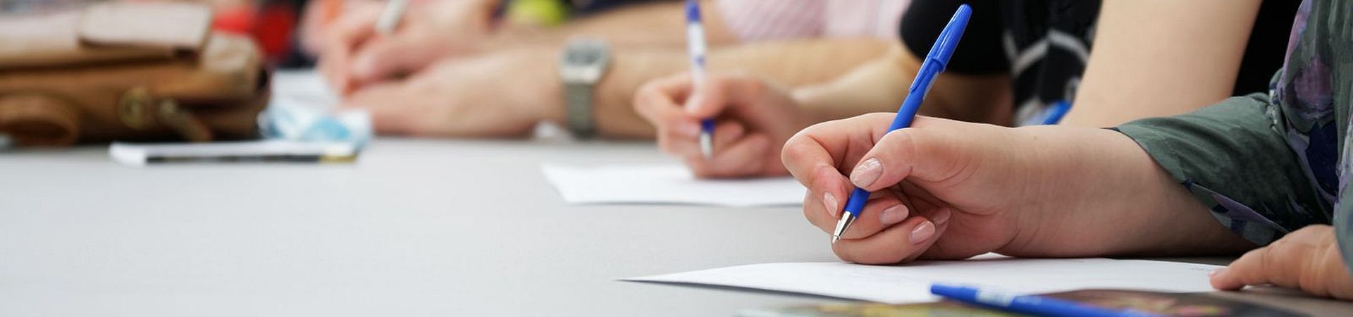 Participantes tomando notas durante una clase